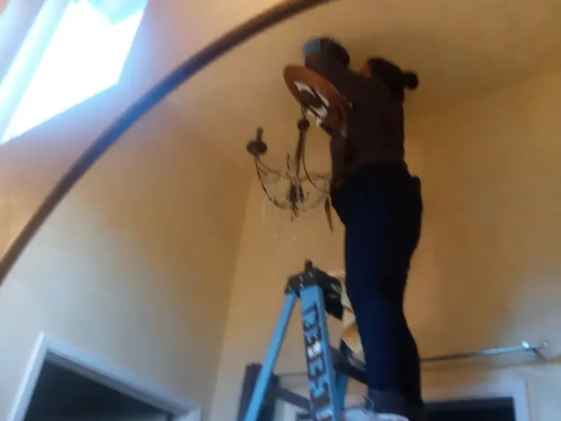 Electrician installing a chandelier in a Lisle residence